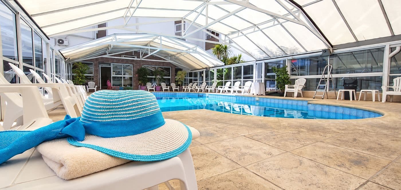 Piscina climatizada cubierta del Gran Hotel Verona con reposeras blancas