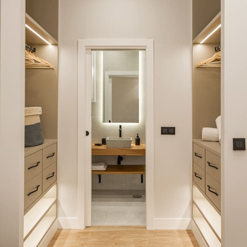Vestidor con baño al fondo en una reforma de Mara Obras